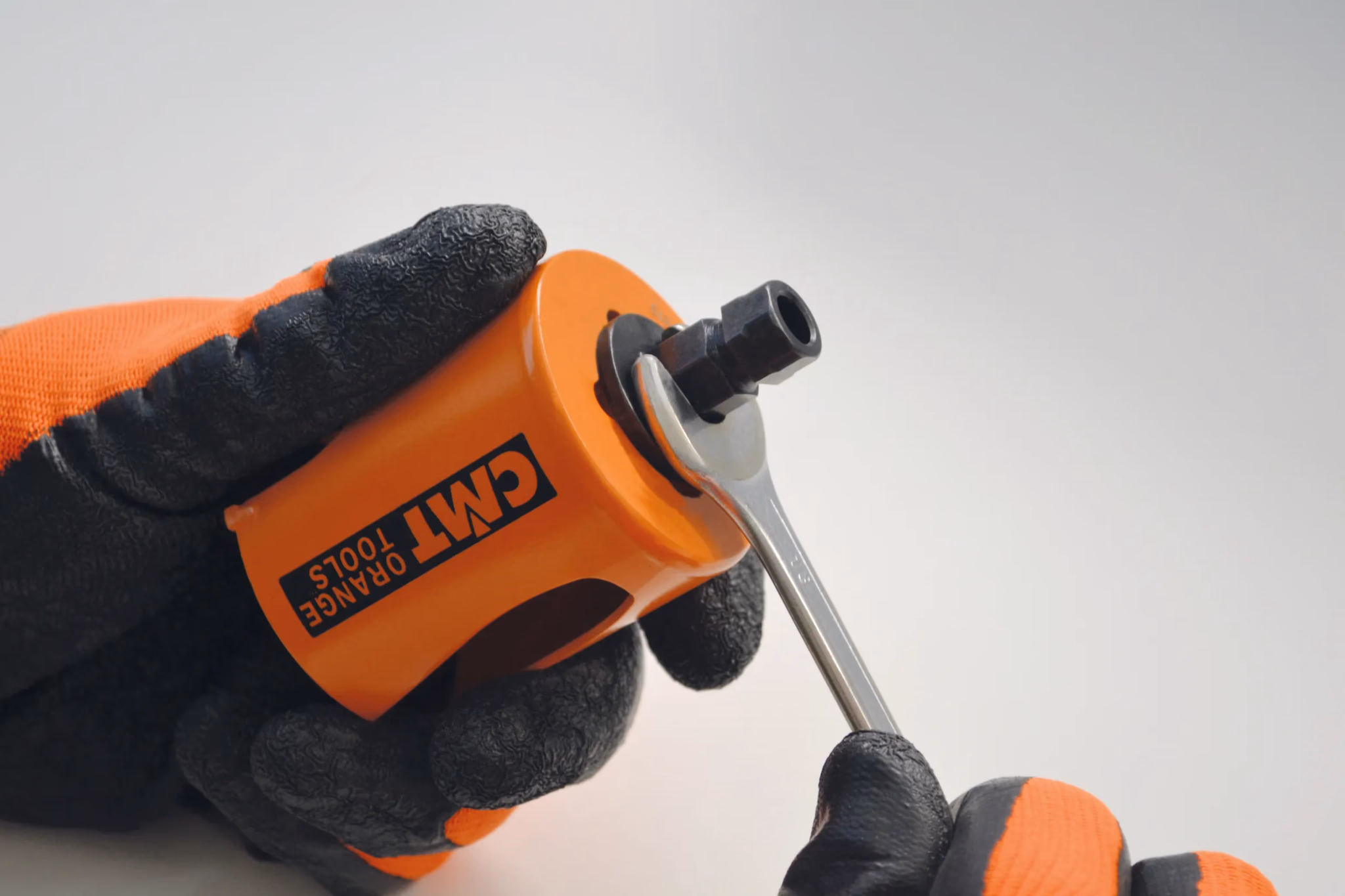 Gehandschoende hand zet een hardmetalen gatzaag vast op de adapter met een inbussleutel
