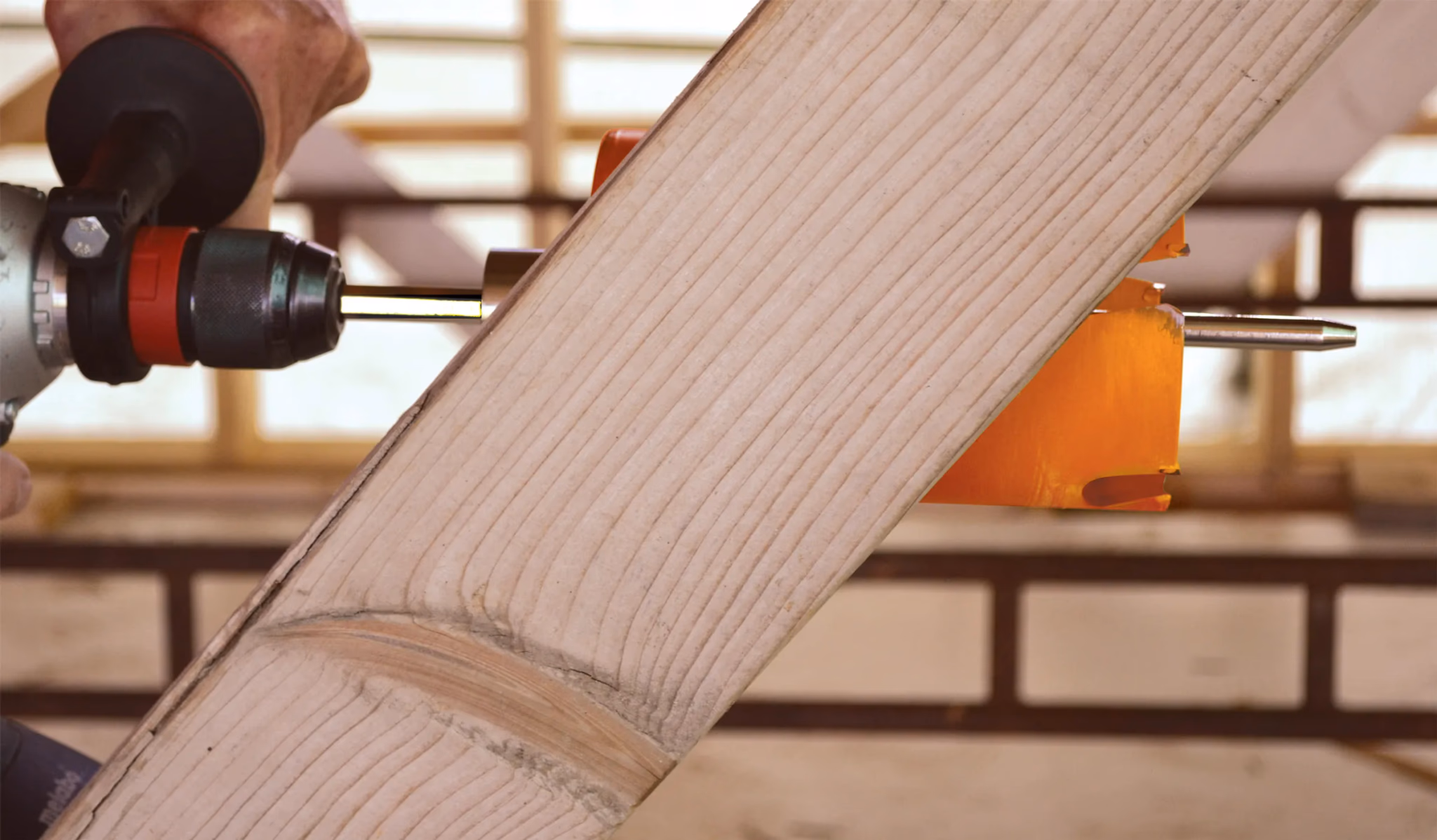 Lange gatzaag boort een doorvoergat in een houten balk
